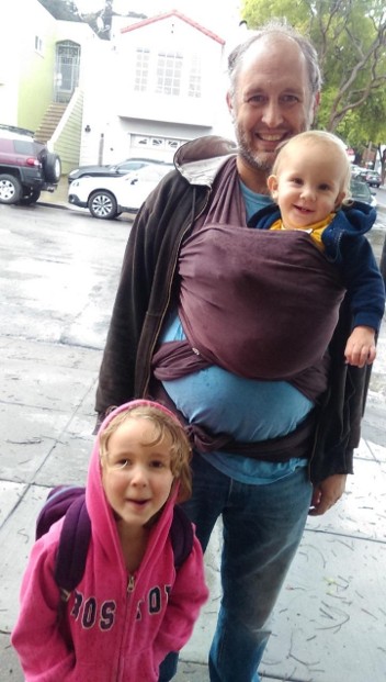 Hamilton Carter with Tawnse in a wrap and Daize peering on